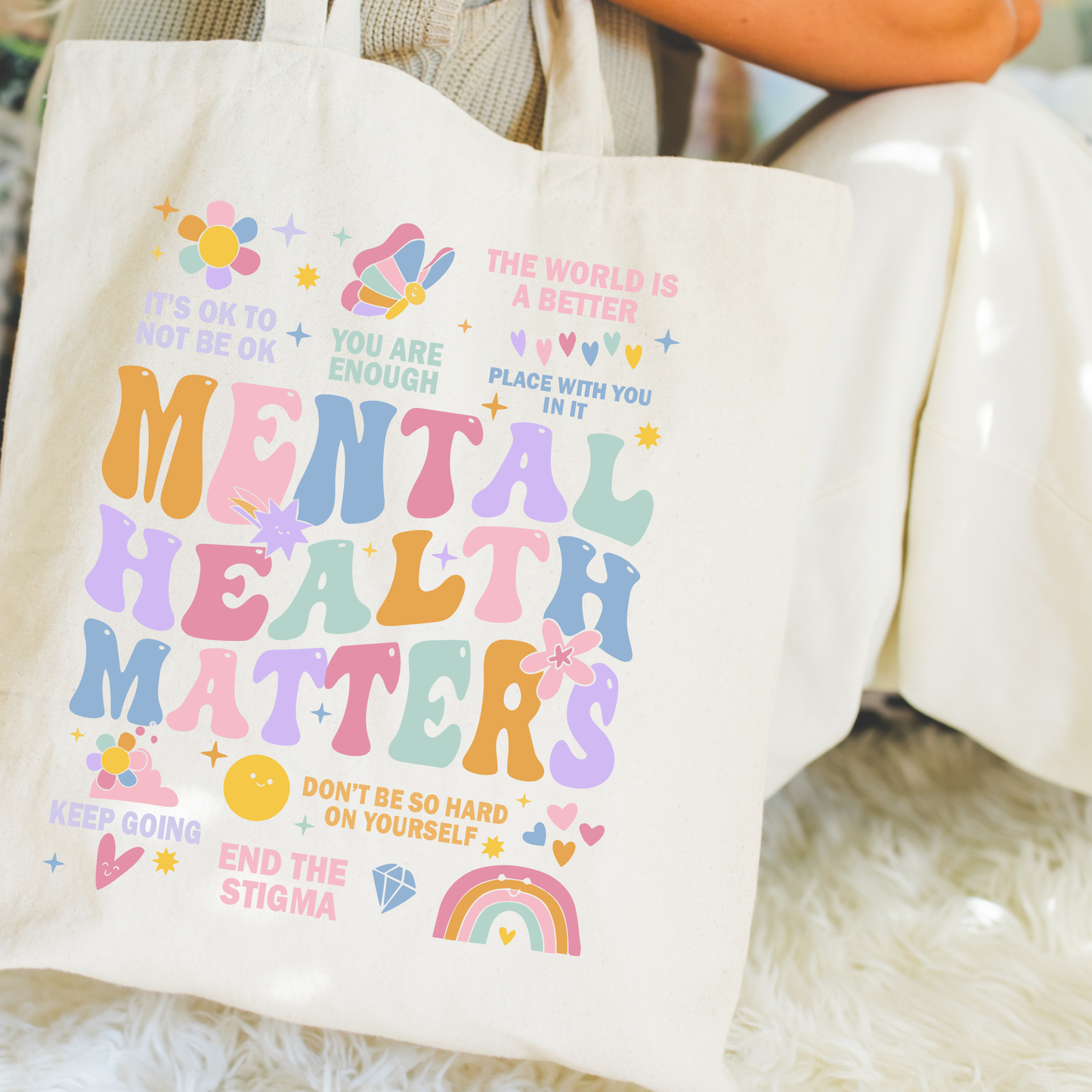 Tote bag with motivational text and colorful graphics on a soft surface