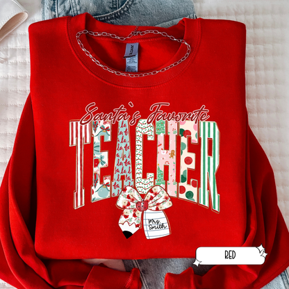 Red sweatshirt with 'Santa's Favorite Teacher' text and graphic on a light background