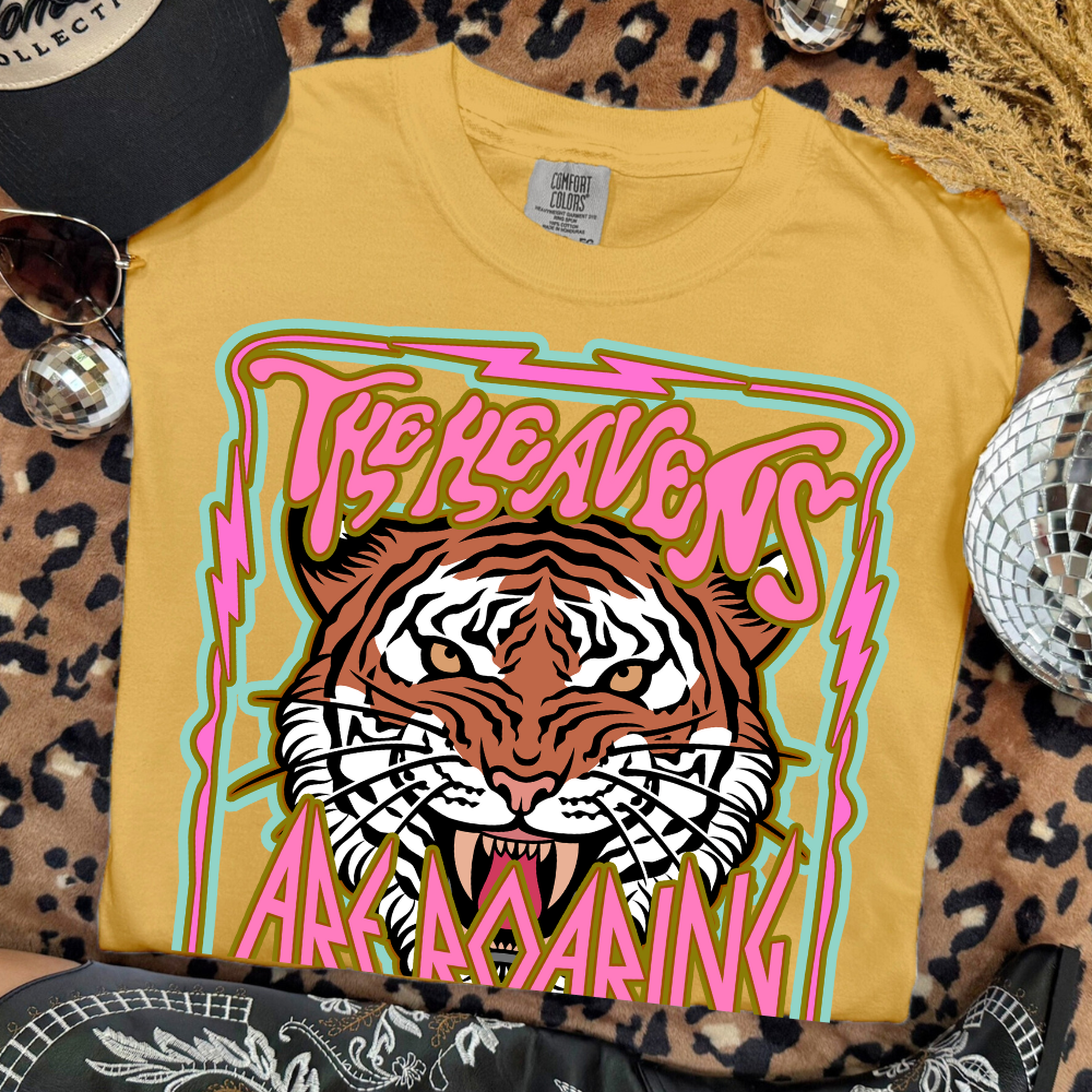 Yellow t-shirt with a tiger graphic and text on a leopard print surface