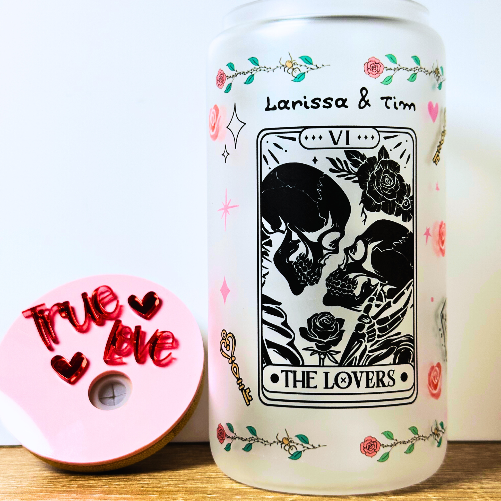 Personalized frosted glass can featuring tarot-inspired “The Lovers” card with skull artwork and custom couple names, bamboo lid included.