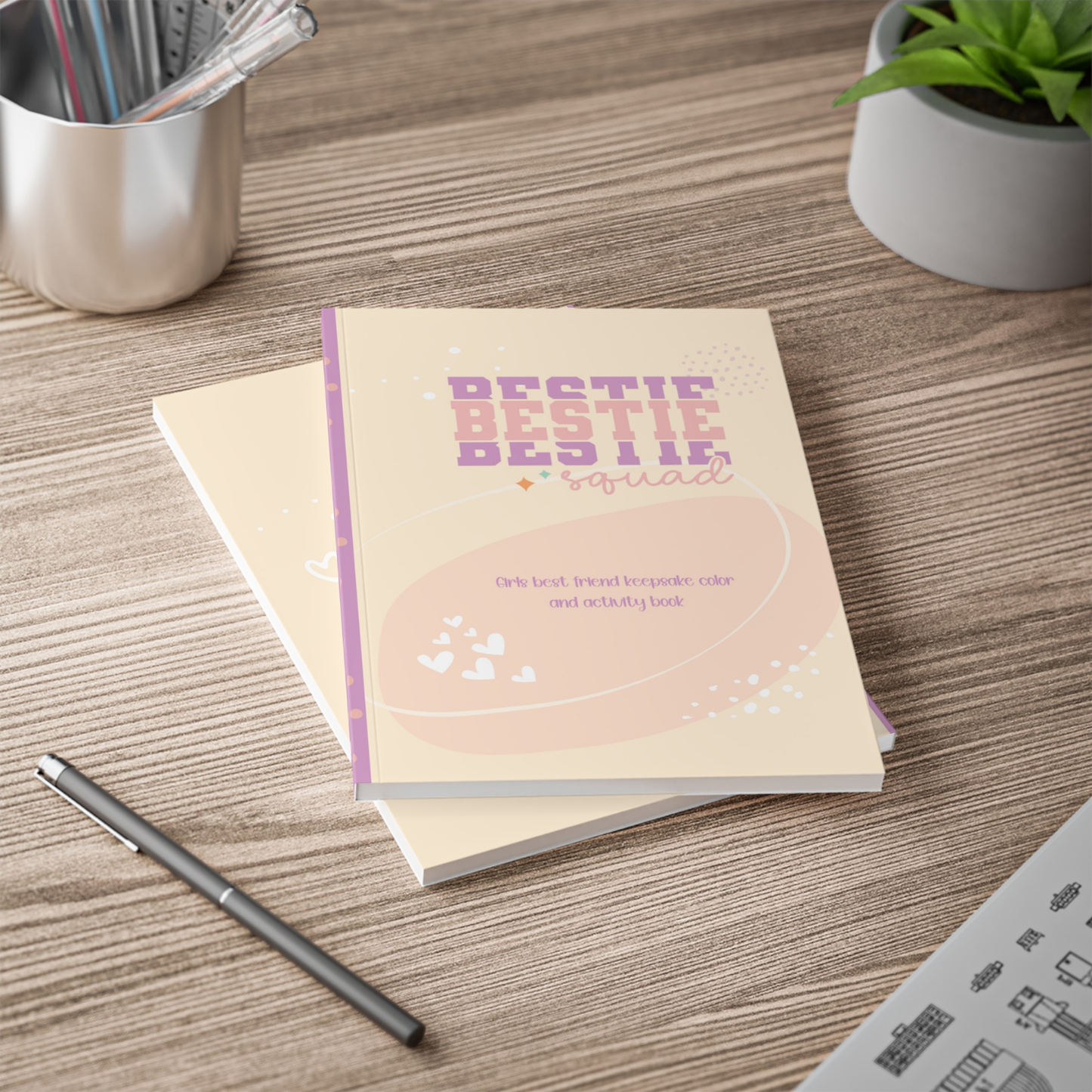 Notebook titled 'Bestie' on a wooden surface with a pen and plant in the background