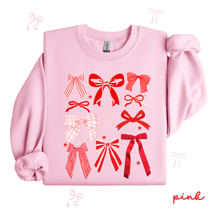 Pink sweatshirt with red bow designs on a white background