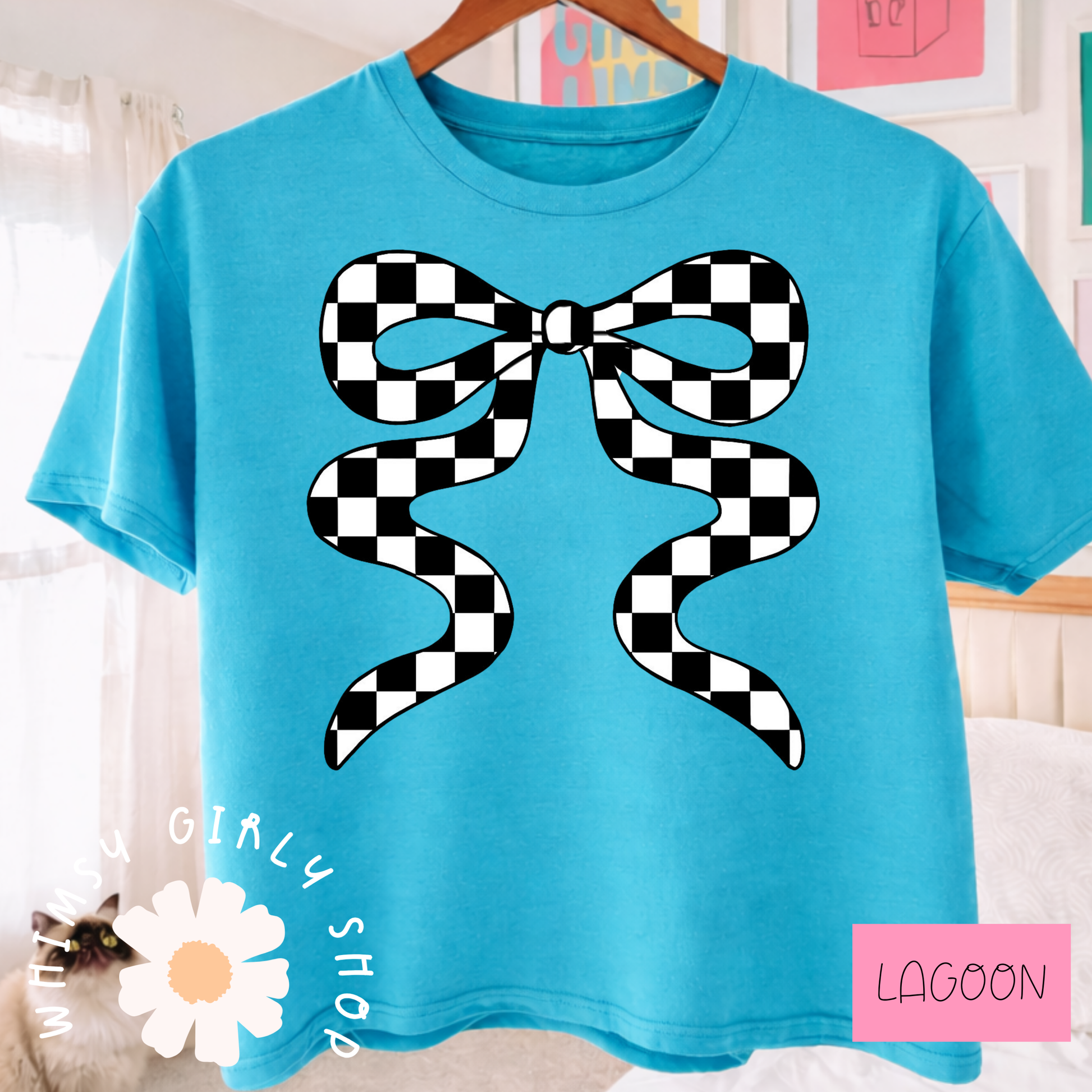 Blue t-shirt with a black and white checkered bow design, hanging on a wooden hanger.