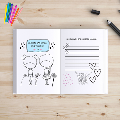 Open book with illustrated pages on a wooden surface with coloring supplies.