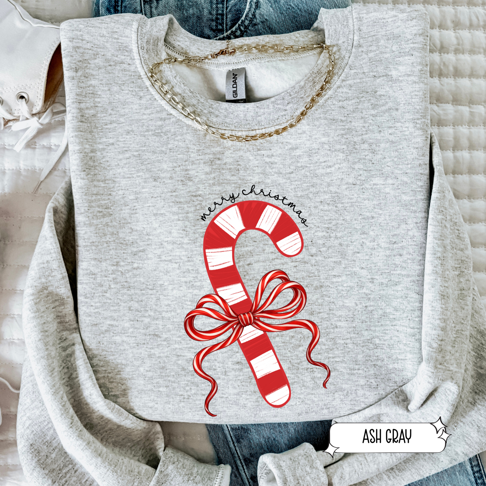 Gray sweatshirt with candy cane design and 'Merry Christmas' text on a textured surface.