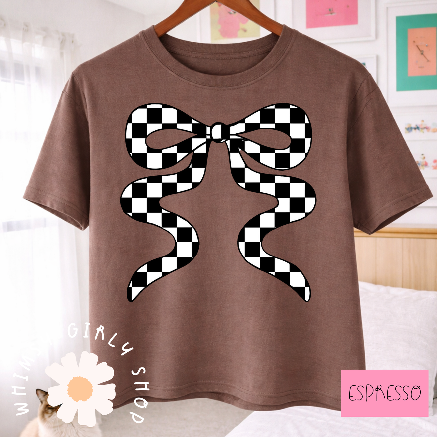 Brown t-shirt with a black and white checkered bow design, hanging on a wooden hanger.