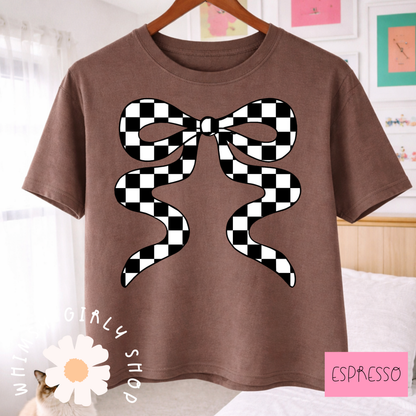 Brown t-shirt with a black and white checkered bow design, hanging on a wooden hanger.