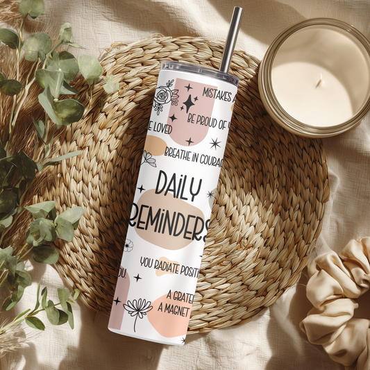 Neutral-toned affirmation tumbler featuring positive phrases like “Daily Reminders,” “You are loved,” and “Breathe in courage,” styled on a woven boho placemat with a candle.