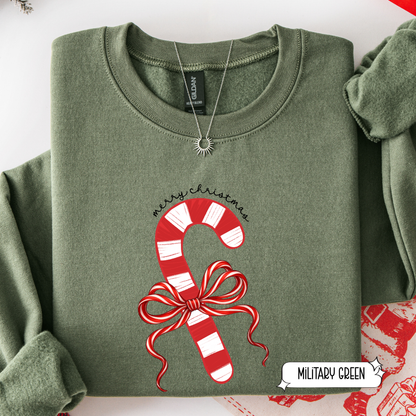 Folded green sweatshirt with candy cane design and 'Merry Christmas' text on a white background.