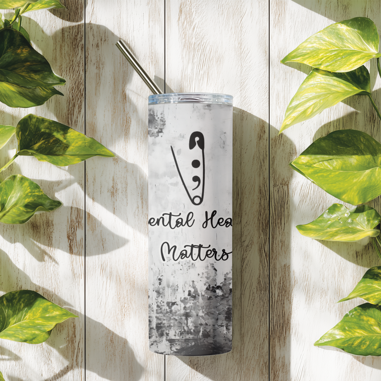 Tumbler with 'Mental Health Matters' text and logo on a wooden surface with leaves.