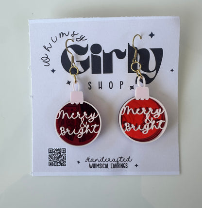 Merry and Bright red ornament acrylic dangle earrings on display card.