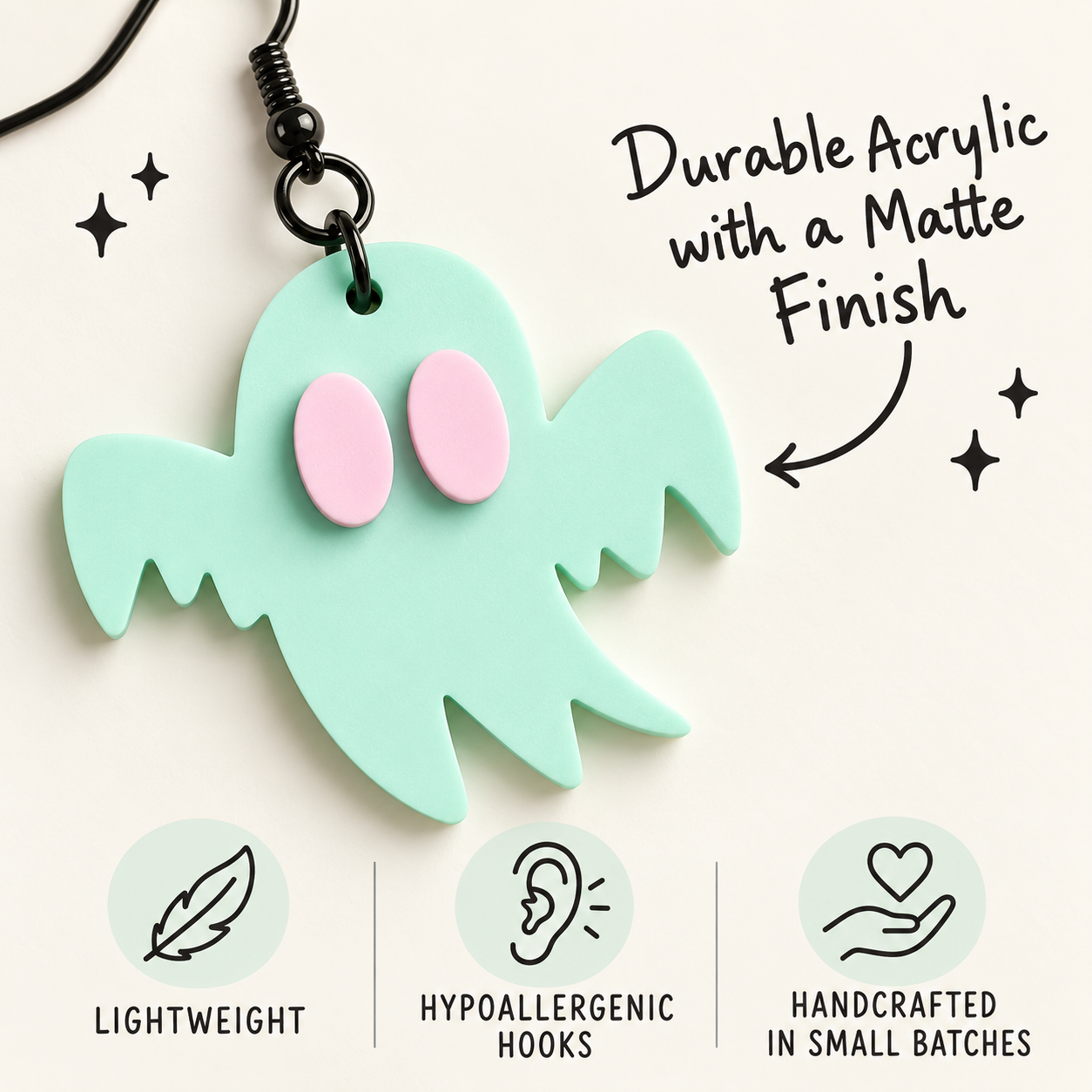 A mint green acrylic ghost keychain with pink eyes, shown on a light cream background with promotional text and feature icons below.