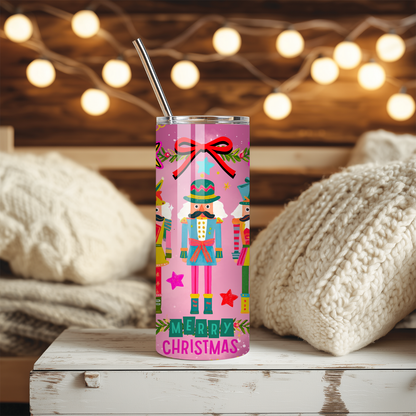 Pink Christmas tumbler with colorful Nutcracker characters, bright stars, ornaments, and festive holiday illustrations on a glossy stainless steel 20 oz cup.