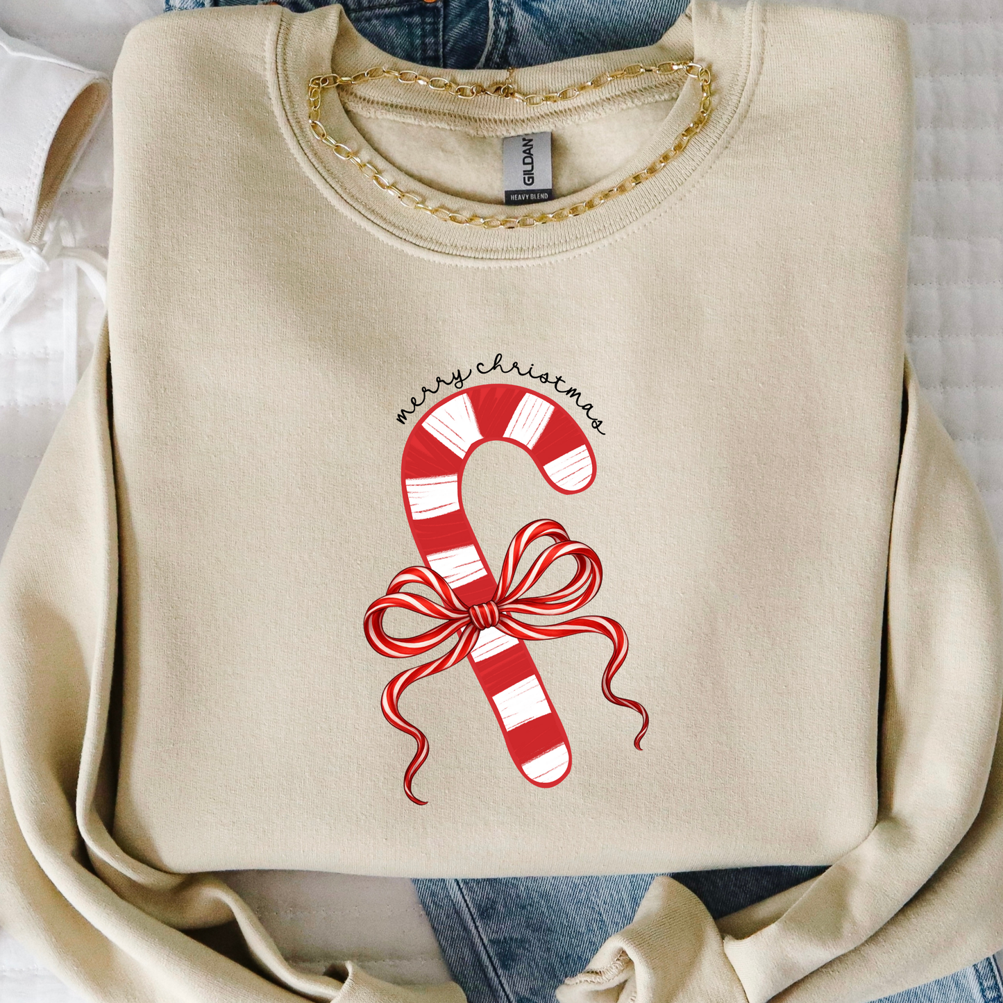 Beige sweatshirt with candy cane design and 'Merry Christmas' text on a white background