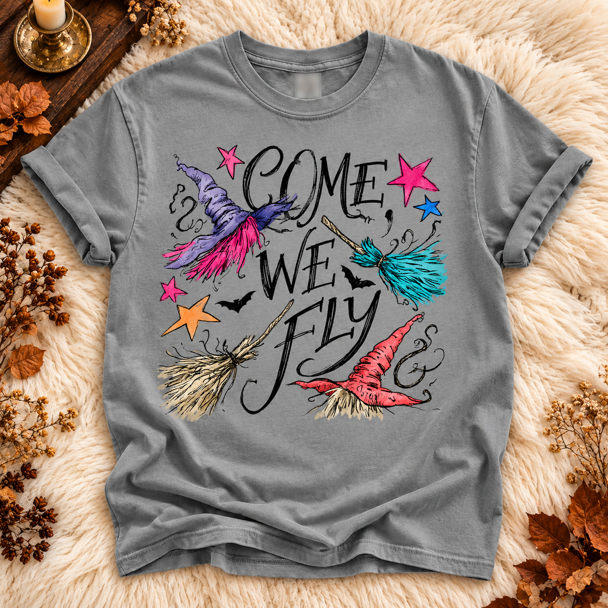 Gray T-shirt with colorful witch hats and broomsticks around the words Come, We Fly