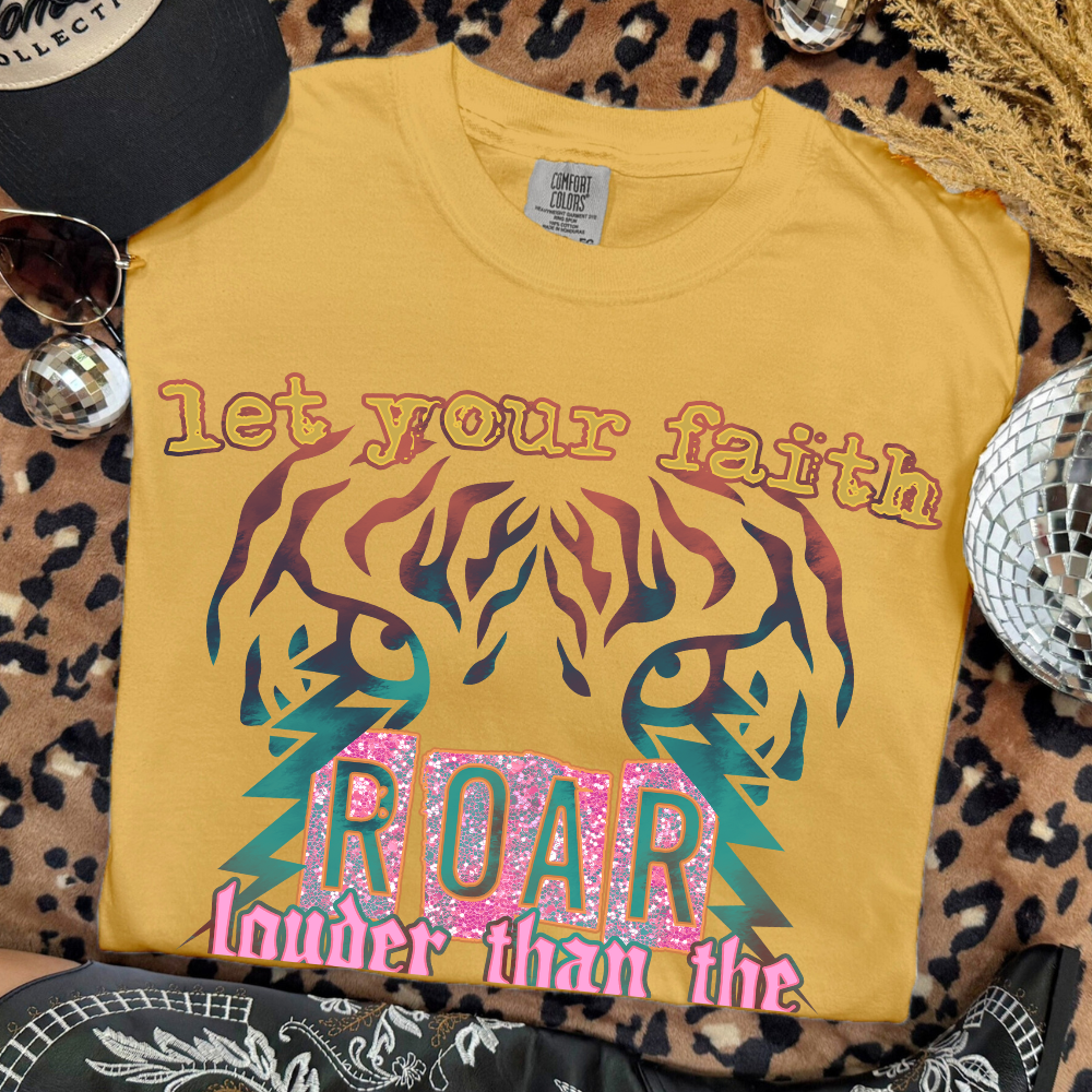 Yellow t-shirt with colorful graphic and text on a leopard print surface