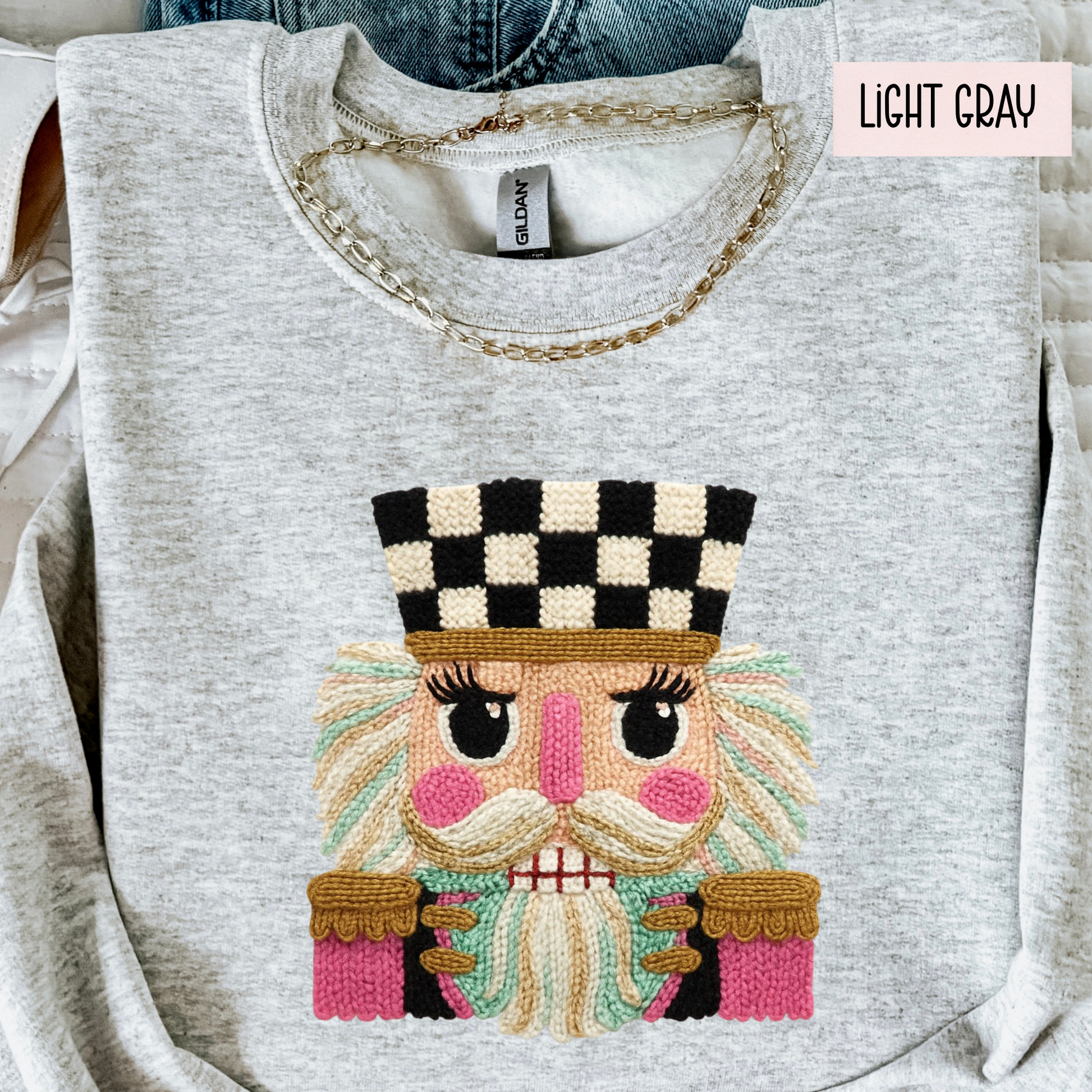 Light gray sweatshirt with faux yarn embroidered face design and 'LIGHT GRAY' label.