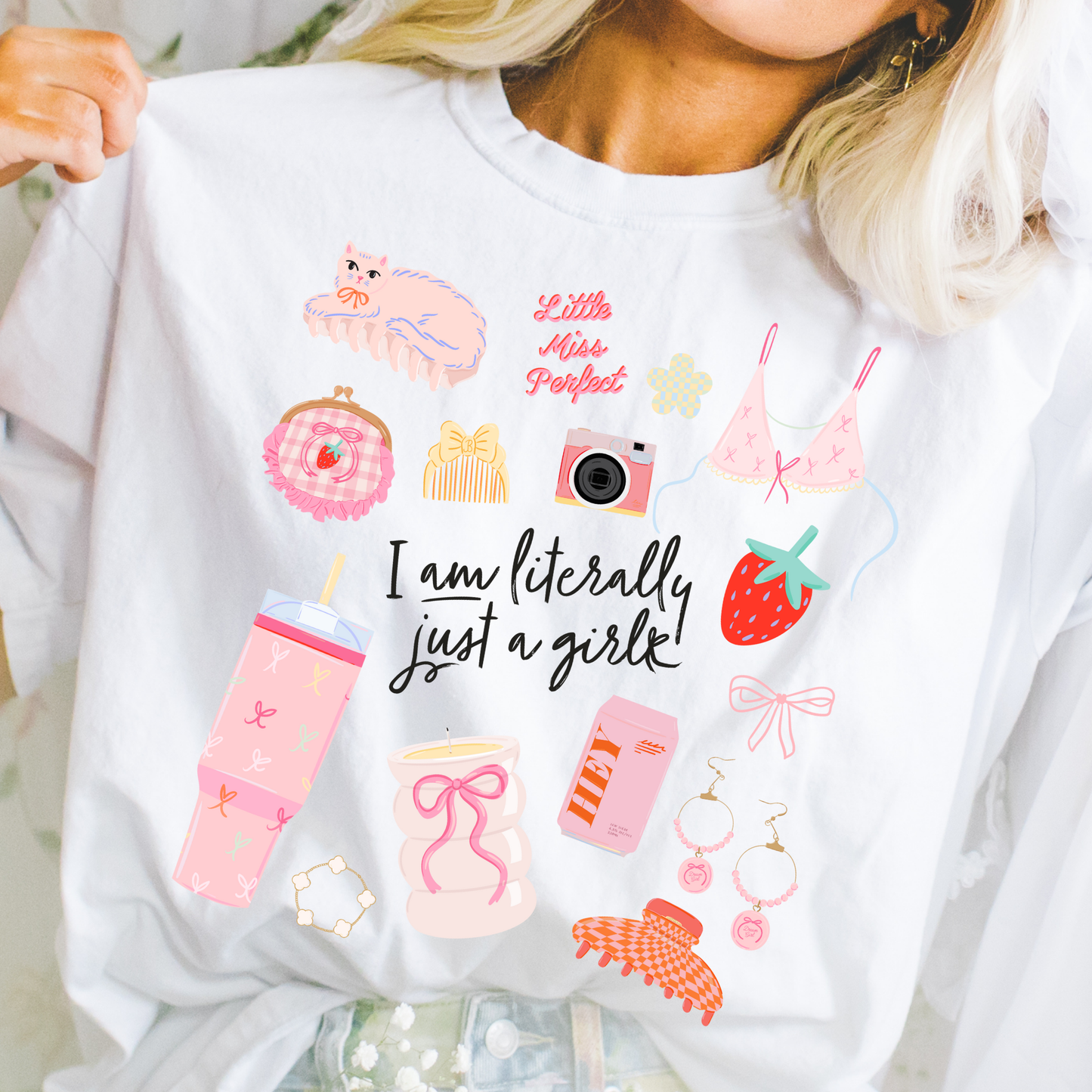 Woman wearing “Literally Just a Girl” graphic t-shirt with playful pastel icons and feminine doodle design