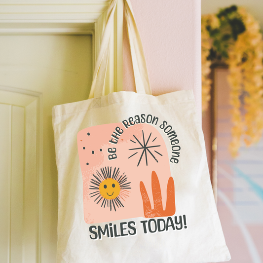 be the reason someone smiles today mental health tote bag hanging on yellow door