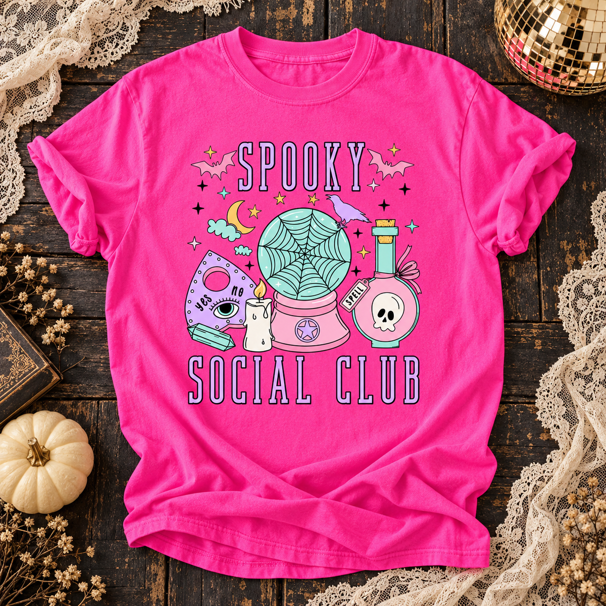 Neon Pink Spooky Social Club T-shirt with pastel ghost radio and Halloween details on dark wood