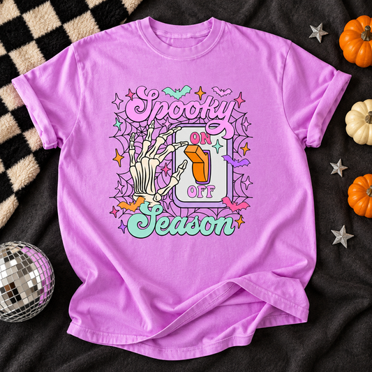 Neon Violet T-shirt featuring Spooky Season Switch skeleton and pumpkin graphic on a Halloween flat lay